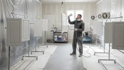 Professional cabinet painting process in Nashville TN showing spray technique for smooth kitchen finishes